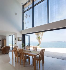 Modern dining space with Visofold 1000 aluminium bifold doors creating a seamless connection to the outdoors.
