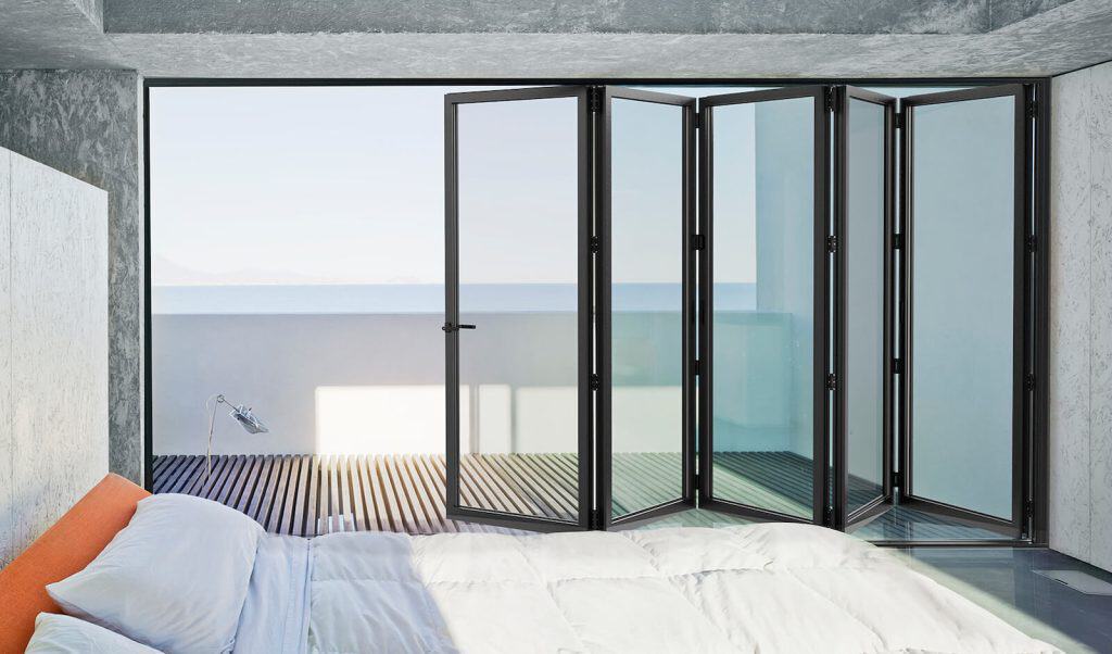 Folding glass doors leading to balcony, offering panoramic sea views and natural light for a stylish.