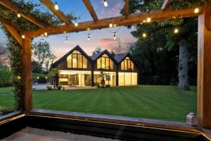 Evening view of a modern home with large COR 70 Tilt and Turn aluminium windows and illuminated open-plan interiors.