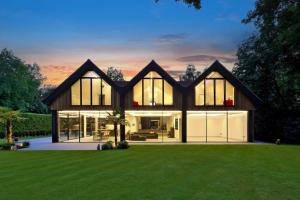 Contemporary house at dusk with large COR 70 Tilt and Turn aluminium windows creating a sleek, light-filled façade.