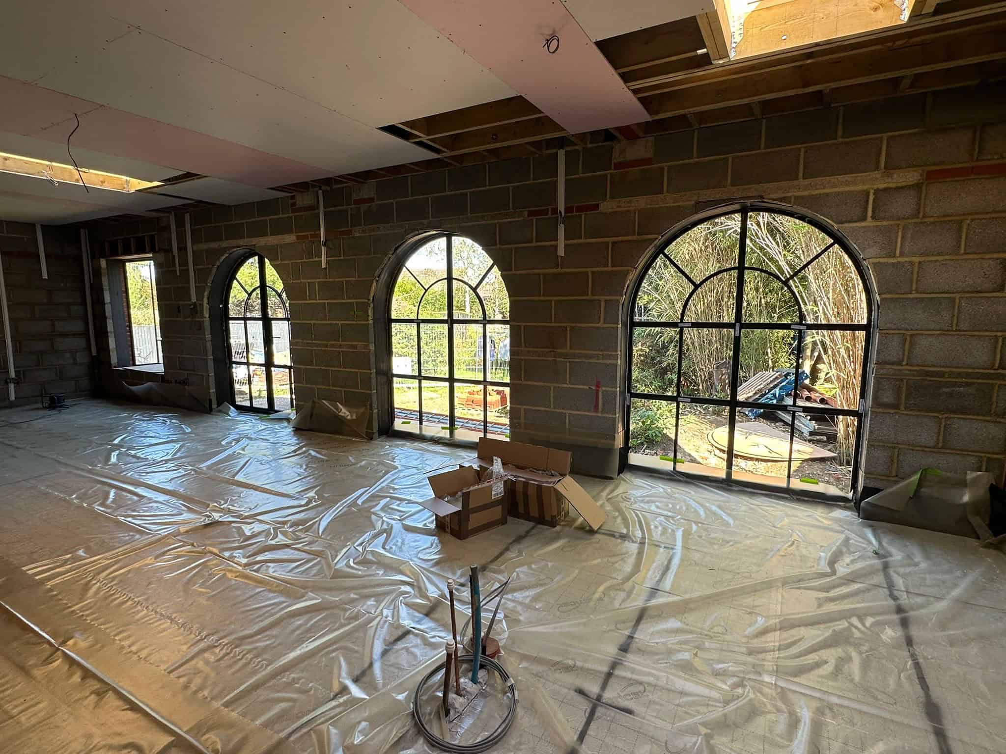 Aluminium windows with arched designs in a building under construction.